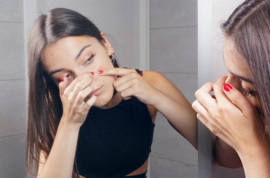 Young Woman Squeezing Pimple 