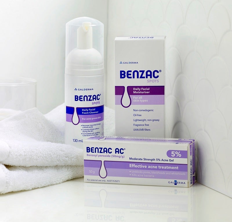 Benzac skincare routine products in bathroom with towel